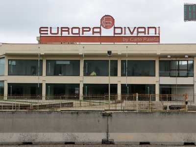 Il salottificio �Europa divani�, la cui targa arancione sovrasta un palazzo bianco e vuoto 
